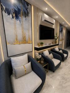 a living room with couches and a flat screen tv at نايس فيو بانوراما للشقق الفندقية in Al Jubail