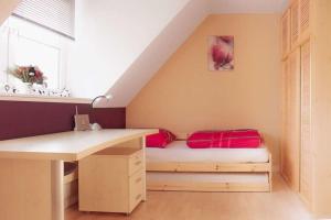 a room with a bed with a desk and a window at Haus Sonnenschein in Dänschendorf +6 photos