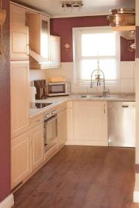 a kitchen with white cabinets and a sink and a window at Haus Sonnenschein in Dänschendorf