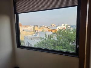 a window in a room with a view of a city at Vrind Orchid- Near Prem Mandir in Vrindāvan