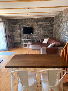 a living room with a wooden table and a couch at Casa do terno com piscina in Arco da Calheta