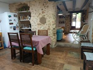 a kitchen with a table and chairs and a stone wall at El Bosquet 1897 in Mogente