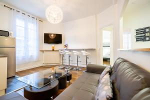 a living room with a couch and a table at Lys Appart in Reims