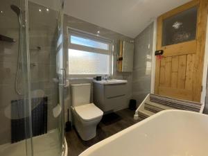 a bathroom with a toilet and a sink and a tub at Ruby's Cottage in Threlkeld +23 photos