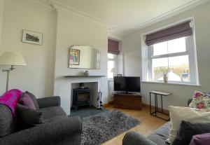 a living room with a couch and a fire place at Ruby's Cottage in Threlkeld