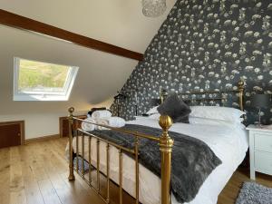 a bedroom with a bed with a black and white wallpaper at Ruby's Cottage in Threlkeld