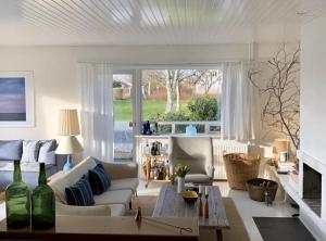 a living room with a couch and a table at Skagen Beach House in Ålbæk