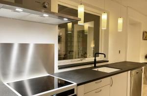 a kitchen with a sink and a large mirror at Skagen Beach House in Ålbæk