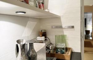 a kitchen with a counter with vases and a shelf at Skagen Beach House in Ålbæk +32 photos