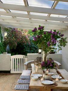a wooden table with purple flowers on a patio at Skagen Beach House in Ålbæk