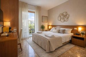 a bedroom with a bed and a desk and a window at Mariclà Boutique Rooms with Balcony & Free Parking in Verona