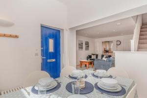 a dining room with a table and chairs and a blue door at 3 Bed in Chathill oc-61892 in Beadnell