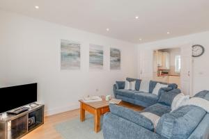 a living room with two blue couches and a tv at 3 Bed in Chathill oc-61892 in Beadnell