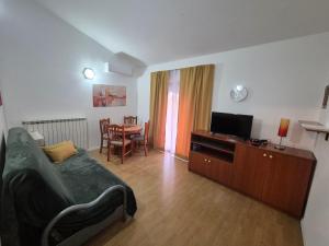a bedroom with a bed and a television and a table at Apartments Makin by El-Pi Tours in Njivice