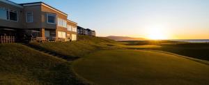 a house on top of a hill with the sun setting at North Lodge - NC500 in Helmsdale