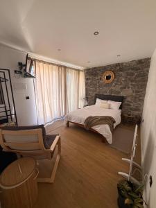 a bedroom with a bed and a brick wall at Casa do terno com piscina in Arco da Calheta +17 photos