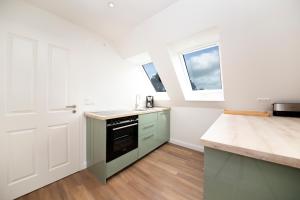 a kitchen with white cabinets and a black dishwasher at Appartement Schleipanorama in Rabenkirchen-Faulück