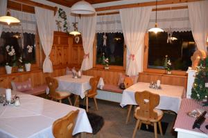 un ristorante con due tavoli e sedie e alberi di Natale di Hotel Gasthaus Schwarzenstein a Ginzling
