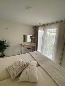 a bedroom with a large bed with a window at Beach House nr 69, dichtbij strand Ouddorp in Ouddorp
