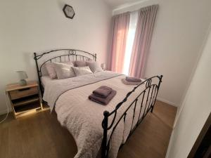 a bedroom with a large bed with a clock on the wall at Apartments Makin by El-Pi Tours in Njivice