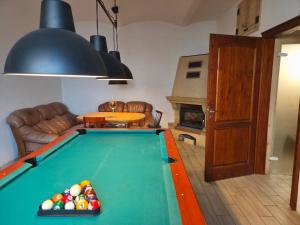 a living room with a pool table and a fireplace at White Haven Private Sauna & Pool in Chřibská