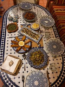 a table with blue and white plates on it at Tigmi Blue - Imsouane Surf et Océan in Imsouane