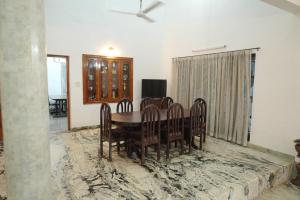 a dining room with a table and chairs at Pulimada Stays in Trichūr