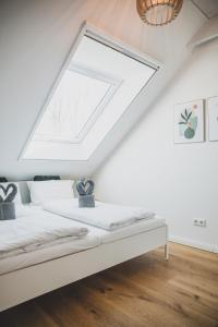 a bed in a room with a skylight at Van Senden 5 Anni in Krummhörn