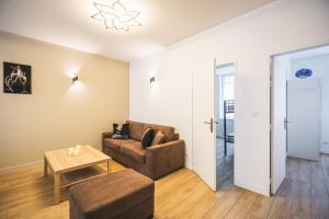 a living room with a couch and a table at Lys Appart in Reims