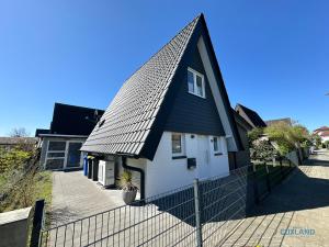a black and white house with a black roof at Ferienhaus am Ringwall 19 in Cuxhaven