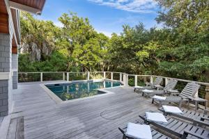 a deck with a swimming pool and chairs on a house at SS59: 59 Surfsong in Kiawah Island