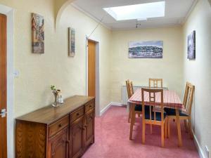 a dining room with a table and a table and chairs at Dunrigh Cottage in Blackwaterfoot