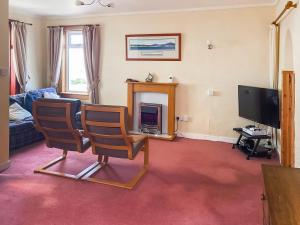 a living room with two chairs and a television at Dunrigh Cottage in Blackwaterfoot