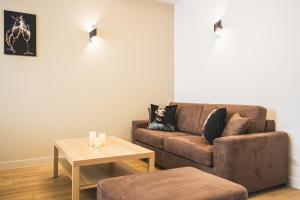 a living room with a brown couch and a table at Lys Appart in Reims +68 photos