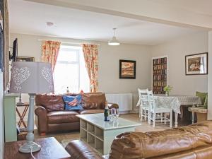 a living room with a couch and a table at Arthurs Cottage - Uk51636 in Kirkbean
