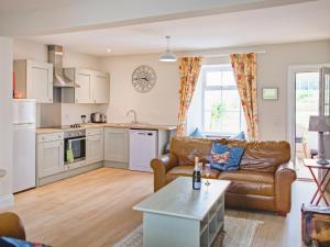 a living room with a couch and a table at Arthurs Cottage - Uk51636 in Kirkbean