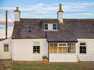 a white house with a white garage at Arthurs Cottage - Uk51636 in Kirkbean