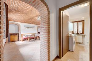 a living room with a brick wall and a dining room at Centenario Affittacamere in Fara Novarese