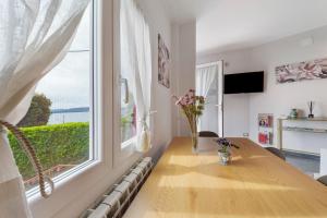 a dining room with a table and a large window at Sunset on the Lake Belgirate in Belgirate