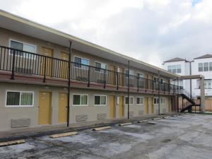 een appartementencomplex met gele deuren en een trap bij Astro Best Inn in Houston