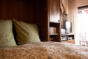 a bed with green pillows in a bedroom with a television at Peaceful Oasis Black Forest in Schonach +19 photos