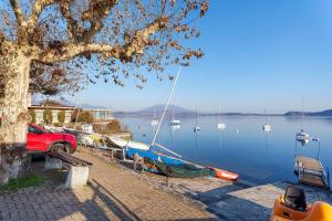 a boat is docked at a dock on a lake at Sunset on the Lake Belgirate in Belgirate