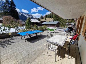 a patio with two ping pong tables and chairs at Le Charme 1, Morgins in Morgins