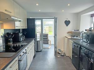 a kitchen with a sink and a stove top oven at Irisdene in Tintagel