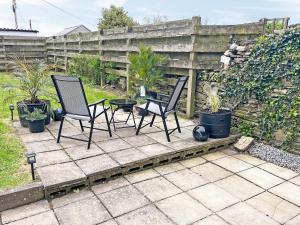 two chairs and a table on a patio at Irisdene in Tintagel
