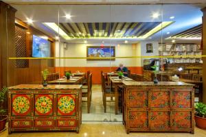 ein Restaurant mit Tischen und Stühlen und einem Mann im Hintergrund in der Unterkunft Hotel Central Prime in Kathmandu