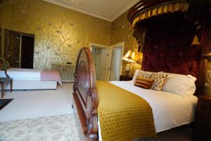 a bedroom with two beds and a canopy bed at Rockfield House in Kells