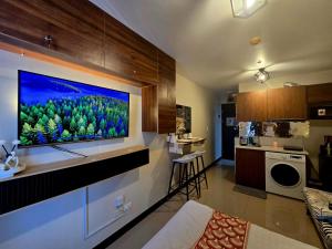 a living room with a large flat screen tv on a wall at staycaSHAWN studio in Lapu Lapu City