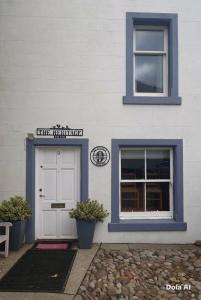 a white building with a door and two windows at The Heritage Guest House in Montrose