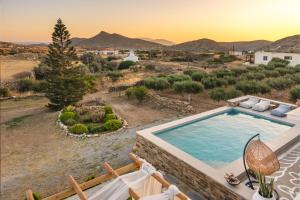 an outdoor swimming pool with a view of the mountains at Revery Villa & House in Ios Chora